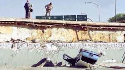A car lies within the destroyed remains of a strip of Los Angeles freeway, after the 1994 earthquake. Theory that helps predict earthquakes could also be applied to economics.