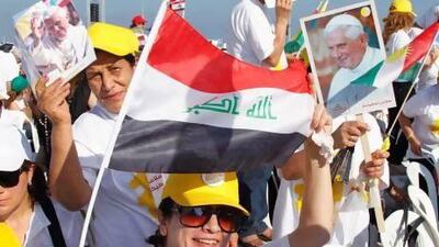 Christians hold up Iraqi and Kurdish national flags, along with Pope Benedict XVI pictures, upon his arrival to conduct an open-air mass in Beirut.