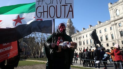 A demonstrator holds a flag and a doll during a Syria solidarity protest outside the Houses of Parliament, in central London. Paul Hackett / Reuters
