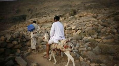 Ali Hassan Al Shehi, 50, rides a donkey to Baqal an area in mountains where his family, the Shehi's have a village. The village is inhabited primarily in the winter months, where they live without electricity and running water.