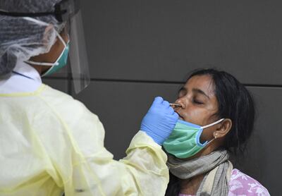 A woman is tested for Covid-19 on arrival at Dubai International Airport. Karim Sahib / AFP
