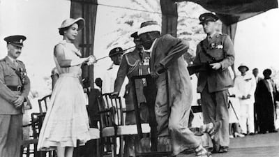 Yemen's councillor Sayyid Abubakr bin Shaikh Alkaff kneels before Queen Elizabeth II to be knighted during her visit to Aden. AFP