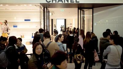 Above, a queue outside a Chanel store in downtown Shanghai. Chinese shoppers are mobbing Chanel stores and counting their savings after the French fashion house slashed handbag prices in the world's biggest luxury market due to the slumping euro. Johannes Eisele / AFP