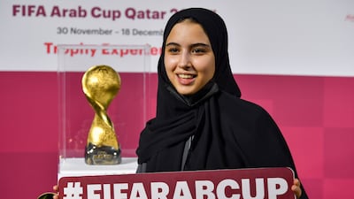A woman poses next to the FIFA Arab Cup Trophy is displayed during the FIFA Arab Cup Trophy Experience at Katara Cultural Village in Doha, Qatar, 25 November 2021. The FIFA Arab Cup will take place in Qatar from 30 November to 18 December 2021. EPA / NOUSHAD THEKKAYIL