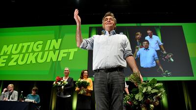 Werner Kogler (R), leader of the Austrian Green party, gestures to delegates during their party's congress in Salzburg as they enter government for the first time, however later the country was targeted in a cyber attack. AFP / BARBARA GINDL
