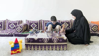Sameera and her son Mohammed play with his Lego set in their Ajman home. Mohammed inherited Ectopia lentis from his mother who is now blind. Reem Mohammed / The National