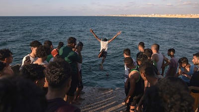 Young Palestinian men jump into the sea at the port in Khan Younis, southern Gaza. EPA