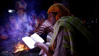 A Hindu priest recites prayers from a holy book while performing a ritual near the bank of Bagmati River during Kuse Aunse (Father’s Day) at Gokarna Temple in Kathmandu, Nepal. Hindus all over the country, whose fathers have passed away, come to the temple for worship, holy dips, and to present offerings on this occasion. Navesh Chitrakar / Reuters