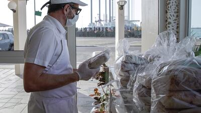 Raj Dagstani arranges his pre ordered pizzas ready for pick up in a Covid-19 compliant environment. Victor Besa / The National