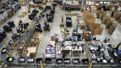Workers prepare customer orders for dispatch as they work around goods stored inside an Amazon.co.uk fulfillment centre in Peterborough. AFP