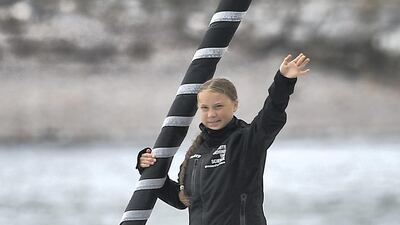 Swedish climate activist Greta Thunberg waves from aboard the Malizia II IMOCA class sailing yacht off the coast of Plymouth, southwest England, on August 14, 2019, as she starts her journey across the Atlantic to New York where she will attend the UN Climate Action Summit next month. AFP