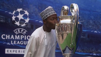 Kenyan Ali Muhidin Ali kisses the UEFA Champions League trophy that was on display at Yas Mall yesterday. Christopher Pike / The National