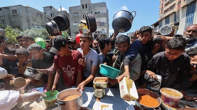 Palestinians queue for food distributed by a charity kitchen at the Nuseirat refugee camp in central Gaza on May 5. AFP
