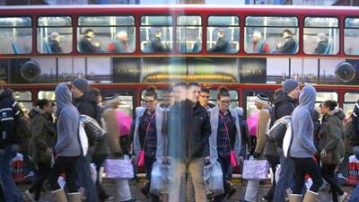 Shoppers are reflected in a shop window as they walk along Oxford Street on the last Saturday before Christmas. REUTERS/Luke MacGregor