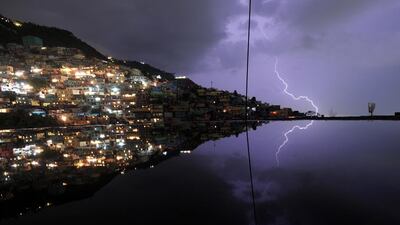 A long exposure shows lightning in the sky with reflection in the water on the floor of a building under construction during an evening thunderstorm in the Haitian capital Port-au-Prince. Hector Retamal / AFP