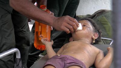 A Sri Lankan soldier cleans the face of a girl after she was found at the site of an explosion. Reuters