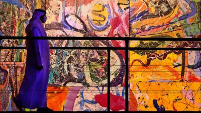 A visitor looks at a section of British contemporary artist Sacha Jafri's painting 'The Journey of Humanity' in Dubai. AFP