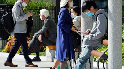 People in face masks are seen at a park, in Tokyo. AP Photo