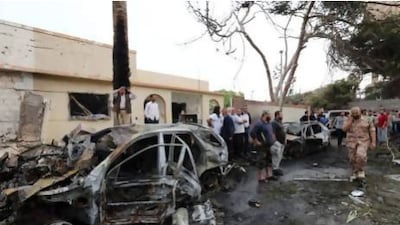 Libyan security forces and civilians gather outside across the street from the French embassy in Tripoli following a car-bomb attack, on April 23, 2013. A car bomb blasted the embassy of France in Tripoli, injuring two French guards and causing serious damage to the building, embassy and Libyan sources said. AFP PHOTO/MAHMUD TURKIA