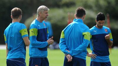 Arsenal manager Arsene Wenger, second right, runs a team training session on Monday. Olly Greenwood / AFP / August 18, 2014