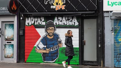 A mural depicting Motaz Azaiza in front of a Palestinian flag painted on a shop blind in Tower Hamlets, east London. Getty Images