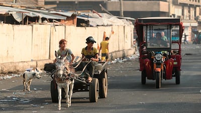 People use a cart and a tuk-tuk to move around after a curfew was announced, in Baghdad, Iraq. AP Photo
