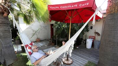 Michael Antonorsi, Chief Joy Activator at Chuao Chocolatier, sits in a hammock while working on a laptop from his beachfront home during the outbreak of the coronavirus in Leucadia, California, USA. Reuters