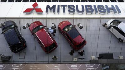 Mitsubishi vehicles reflected on a mirror at Mitsubishi Motors' headquarters in Tokyo, Japan. Executives may see their salaries soar despite revelations of a data falsification scandal that emerged this year. Franck Robichon / EPA