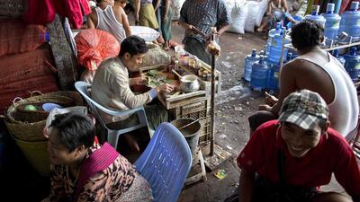 People gather around a “kun-ya” seller at a market in Yangon, Myanmar. Gemunu Amarasinghe / AP