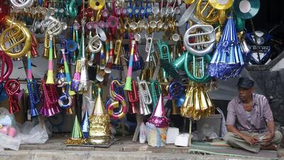 A vendor waits for customers as he sells New Year paper horns in Jakarta, Indonesia. Adi Weda / EPA