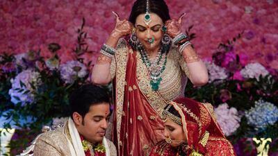 Nita Ambani, center, wife of Reliance Industries Chairman Mukesh Ambani, gestures as her son Akash Ambani, left, and daughter-in-law Shloka Mehta perform a ritual at their wedding ceremony in Mumbai, India. Photo: Reliance Industries Limited Photo via AP