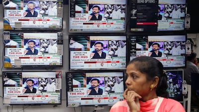 A woman watches a news television debate about Indian opposition leader Rahul Gandhi's hug to Prime Minister Narendra Modi during a no-confidence motion in parliament, at an electronics store in Kolkata, India, July 20, 2018. REUTERS