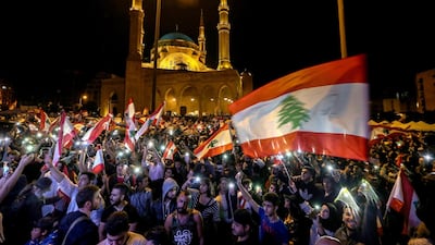 Protesters wave Lebanese flags and shout anti-government slogans during a protest in front Al-Ameen mosque in downtown Beirut. EPA