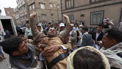 Shiite Houthis help a fellow protester suffering from tear gas inhalation during clashes with riot police near the cabinet building in Sanaa on Tuesday. Mohamed Al Sayaghi / Reuters