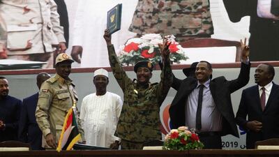 Sudan's protest leader Ahmad Rabie (second right), flashes the victory gesture alongside General Abdel Fattah al-Burhan (centre), the chief of Sudan's ruling Transitional Military Council (TMC), during a ceremony where they signed a "constitutional declaration" that paves the way for a transition to civilian rule, in the capital Khartoum. AFP