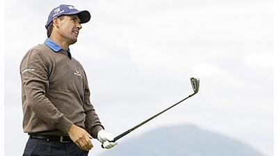 Padraig Harrington follows a shot from the fourth tee, as Ailsa Craig Island is seen in the background, during the third round today.
