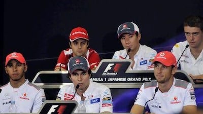 Sergio Perez, front centre, sits between Lewis Hamilton and Jenson Button.