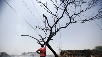 A resident stands next to the debris of huts after a fire broke out in a slum area in New Delhi. Hundreds of huts were gutted in the fire but no casualties were reported and the cause of the fire was unknown, slum dwellers said on Friday. Anindito Mukherjee / Reuters / April 25, 2014