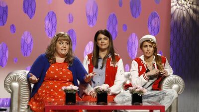 This October 5, 2013 photo released by NBC shows, from left, Aidy Bryant, Cecily Strong, and guest host Miley Cyrus in a scene from the late-night comedy series Saturday Night Live. Dana Edelson / AP Photo / NBC