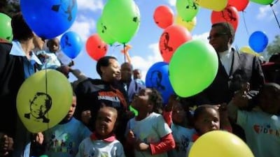 Children gather to celebrate the 95th birthday of their “Father of the Nation”, Nelson Mandela, outside the Mediclinic Heart Hospital where he is being treated.