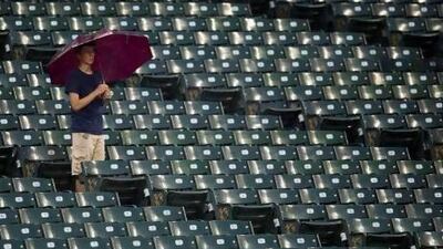 A fan waits out the rain during a delayed start of the game between the Cleveland Indians and the Tampa Bay Rays at Progressive Field on May 31, 2013 in Cleveland.