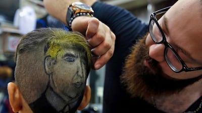 In this Friday, July 14, 2017 photo, Muhannad Khaled Omar, right, prepares an image of U.S. President Donald Trump on the back of a customer's head at his barber shop in Burj al-Barajneh, southern Beirut, Lebanon. In a city full of hair stylists, Omar stands out. He is a 26 year-old Palestinian-Syrian hair stylist known for shaving celebrity portraits into clients’ hair. (AP Photo/Bilal Hussein)