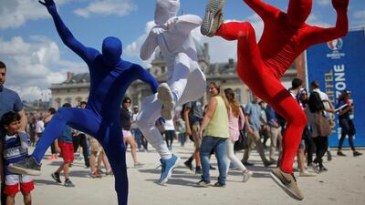 A trio of French fans jump in the air at the football fan zone in Paris. Stephane Mahe / Reuters
