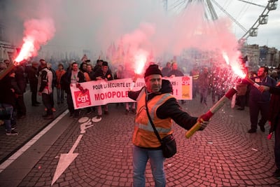 A railworker holds a flare during a mass stirke in the Old Port of Marseille, southern France. AP