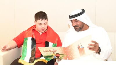 Sheikh Ahmed bin Saeed, chairman and chief executive officer of Emirates airline, reads to a student. Courtesy Rashid Centre for Disabled