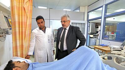 Dr Essam Faraj Dohair, Thalassemia Centre Outreach Coordinator, centre, talks to a patient at Latifa hospital in Dubai. Pawan Singh / The National