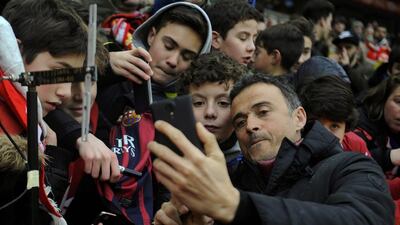 Barcelona’s coach Luis Enrique takes selfies with fans before match. REUTERS/Eloy Alonso
