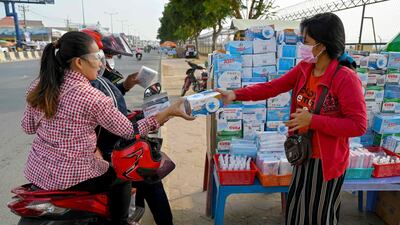 Motorists buy a box of face masks from a vendor along a street in Phnom Penh, Cambodia. AFP