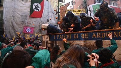 Members of the teams 'I Tuchini del Borghetto' (front) and 'I Falchi di Re Arduino' (on cart) hurl oranges at eachother. AFP