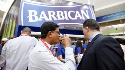 Visitors try out Barbican product samples at the Gufood exhibition. Ali Haider / EPA